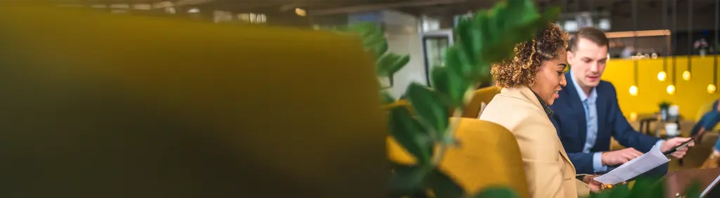 Finanzberatung bei MLP: Beratungsgespräch zwischen MLP Berater und Kundin in modernem Umfeld.