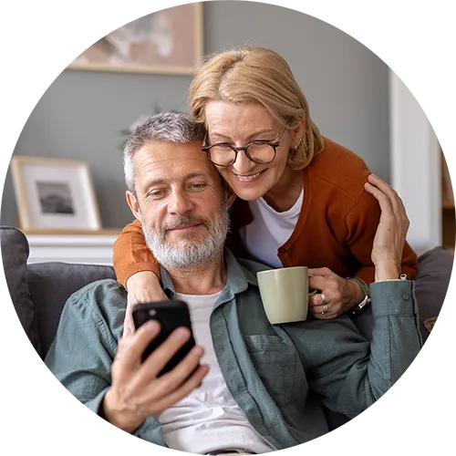 Ein Ehepaar blickt zufrieden auf die abgeschlossene Altersvorsorge. 