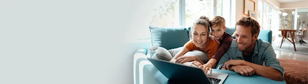 Finanzierung | Familie sitzt auf dem Sofa und schaut in den Laptop