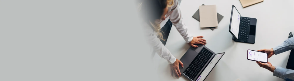Zwei Personen analysieren ihre Anlagestrategie am Smartphone bzw. Laptop und Tablet.