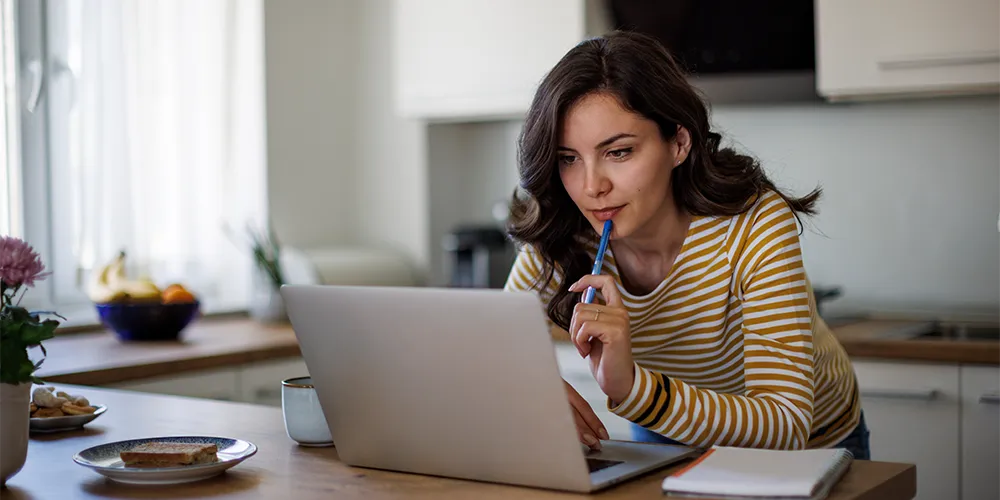 Eine Person überlegt am Laptop, wie genau ein Anleihen-ETF funktioniert.