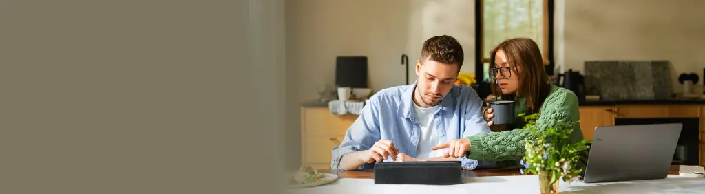 Ein junges Paar sitzt am Laptop und informiert sich über Risiken einer ETF-Geldanlage.
