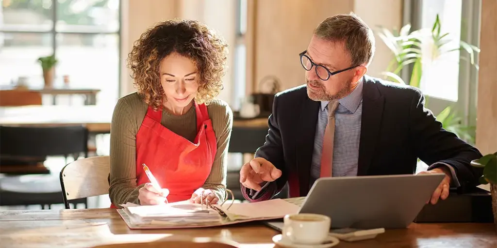 Ein Mann berät eine Frau über Chancen und Risiken festverzinslicher Wertpapiere.