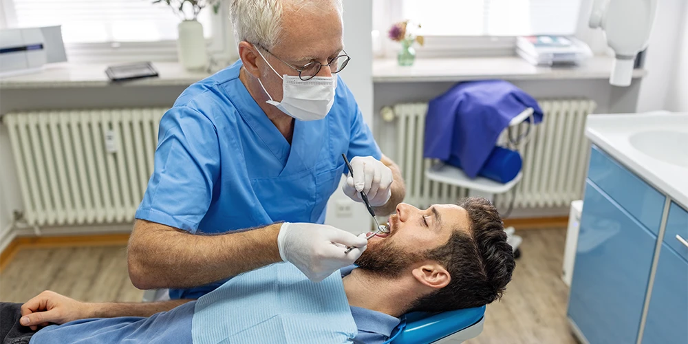 Ein Zahnarzt untersucht die Zähne seines Patienten.