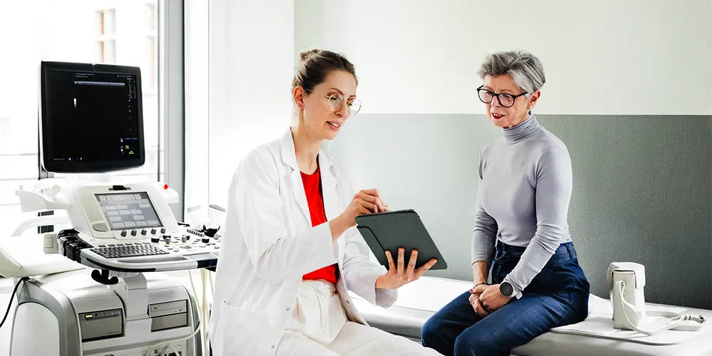 Eine junge Ärztin bespricht nach ihrer Praxiseröffnung mit einer Patientin die Behandlung.