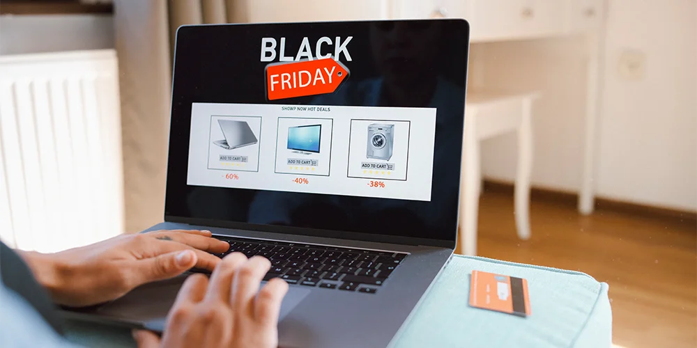 Person kauft Elektronik Online mit Laptop am Black Friday