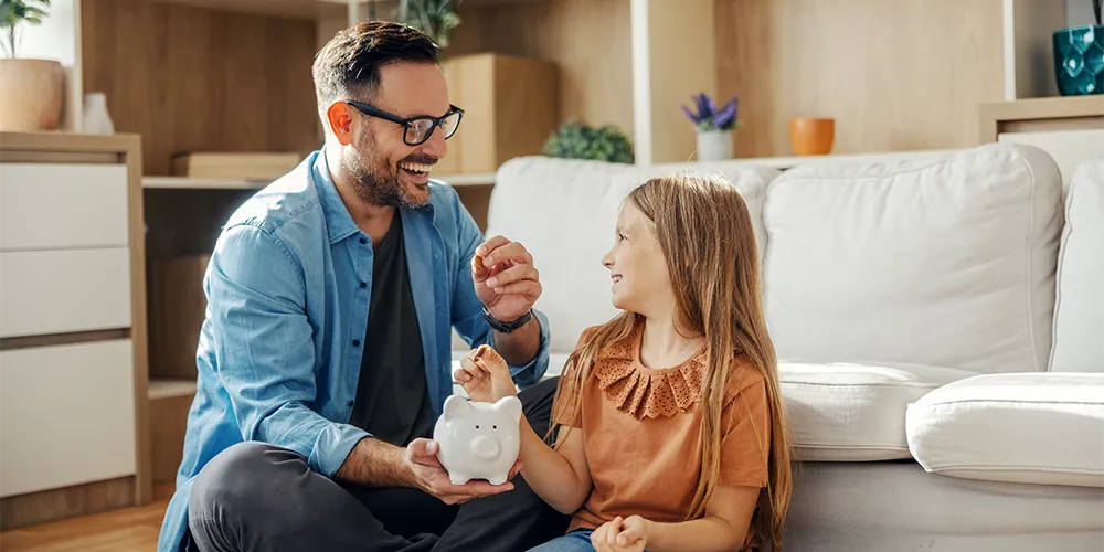 Vater und Tochter mit Sparschwein